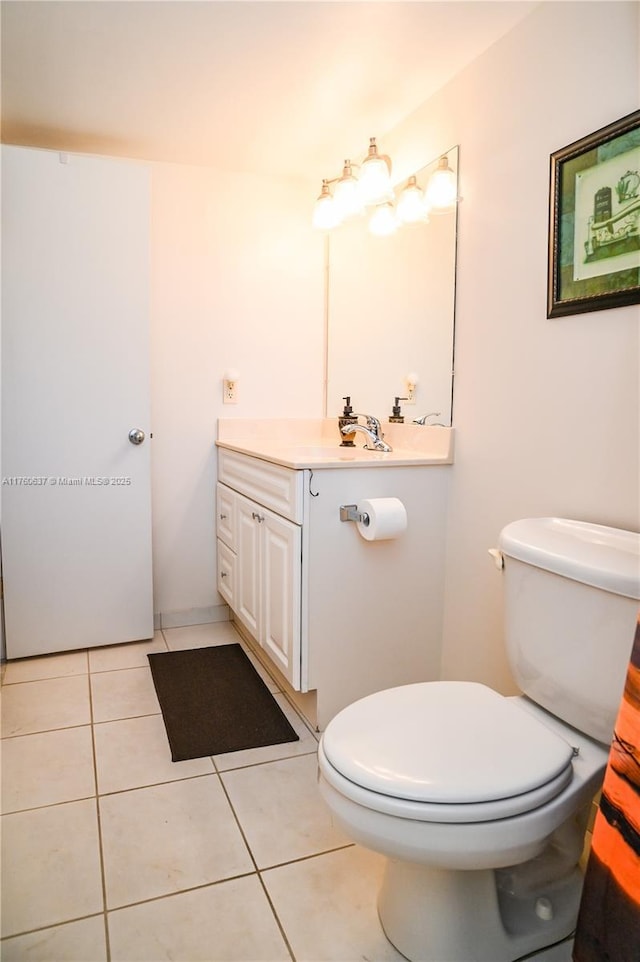 bathroom featuring tile patterned flooring, toilet, and vanity