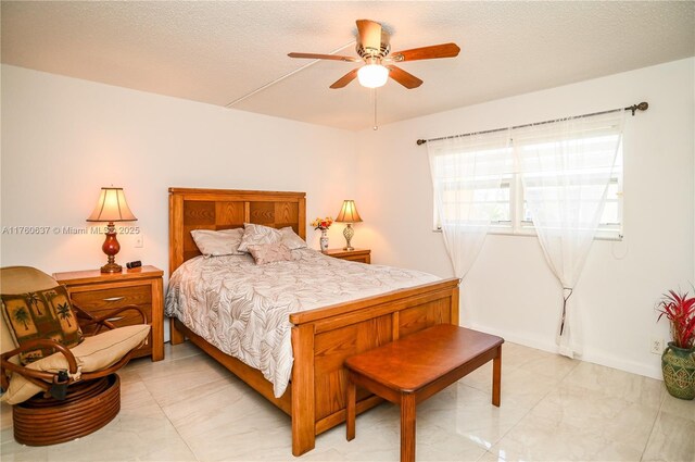 bedroom with ceiling fan and a textured ceiling