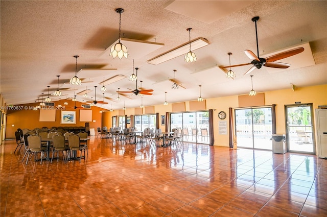 misc room with tile patterned floors, a textured ceiling, lofted ceiling, and a ceiling fan