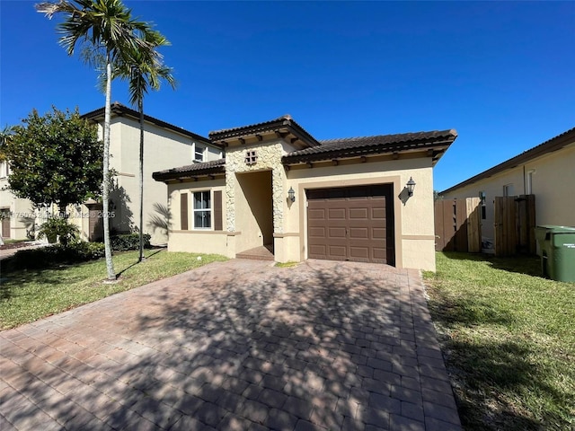 mediterranean / spanish home with stucco siding, a front yard, decorative driveway, and a garage