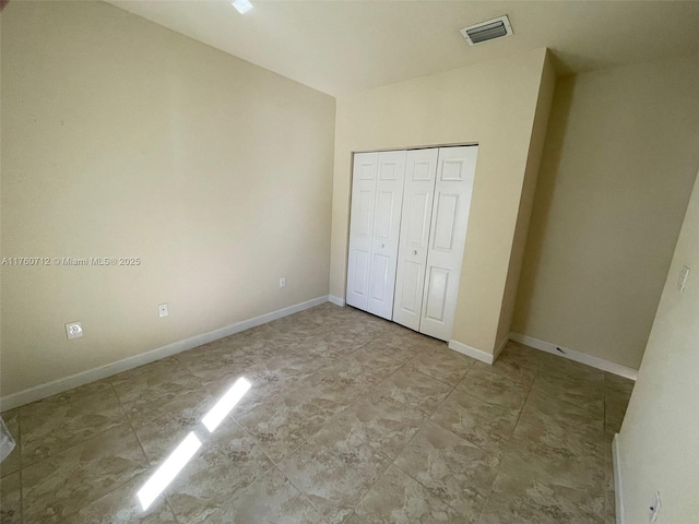 unfurnished bedroom featuring a closet, visible vents, and baseboards