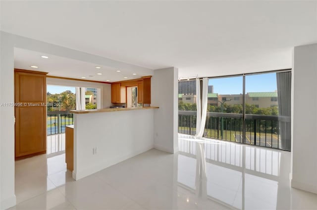 interior space featuring recessed lighting, a peninsula, brown cabinetry, and light tile patterned floors