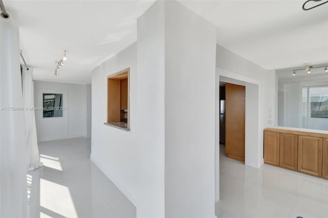 hall with light tile patterned floors and rail lighting