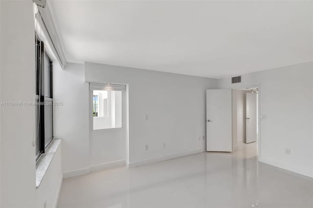 unfurnished room with visible vents and baseboards