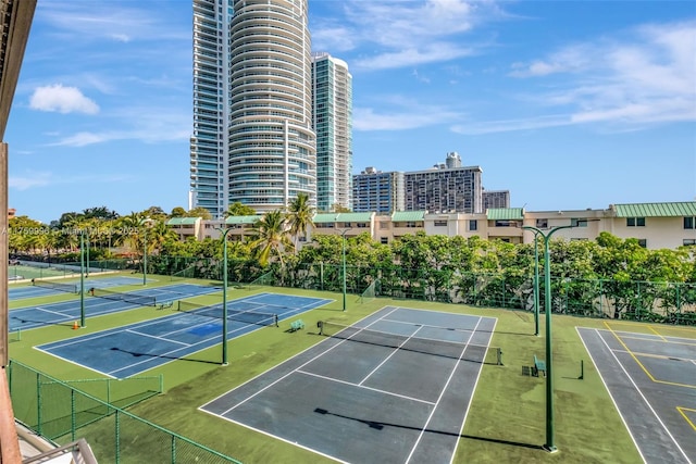 view of sport court with a city view and fence