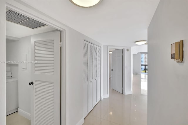 hall with washer / dryer, baseboards, and visible vents