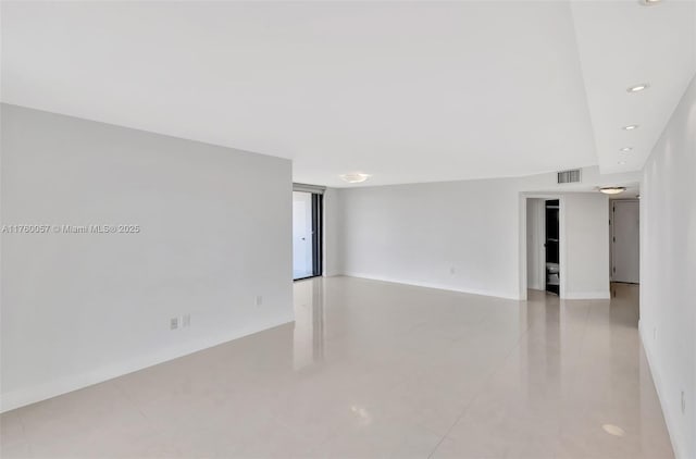 empty room featuring visible vents, recessed lighting, and baseboards