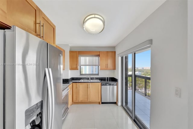 kitchen featuring dark countertops, plenty of natural light, stainless steel appliances, and a sink