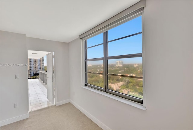 carpeted empty room featuring baseboards