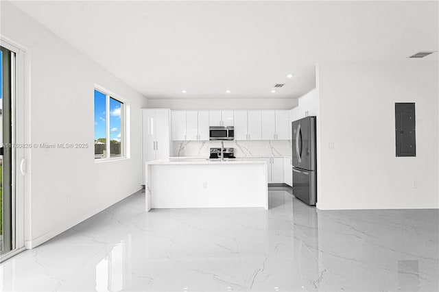 kitchen with electric panel, marble finish floor, appliances with stainless steel finishes, and white cabinetry