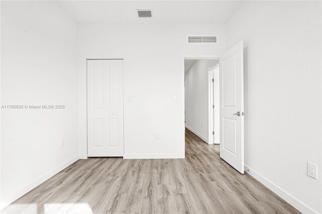 unfurnished bedroom with baseboards, visible vents, and light wood finished floors