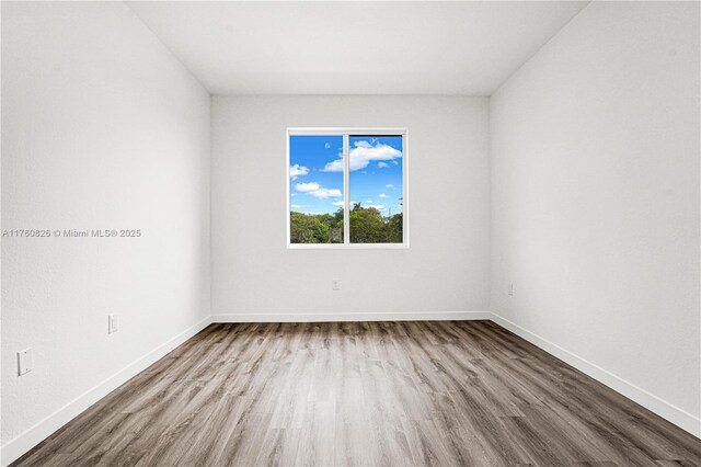 empty room featuring baseboards and wood finished floors