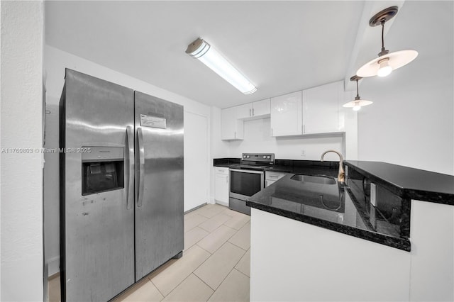 kitchen with a sink, dark stone countertops, stainless steel appliances, white cabinets, and hanging light fixtures