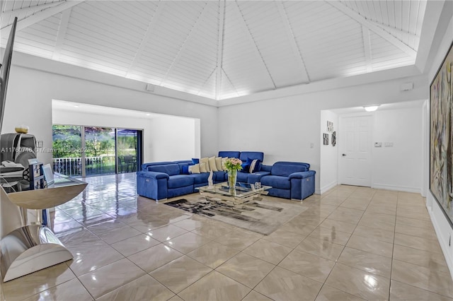 living area featuring light tile patterned floors, beamed ceiling, baseboards, and high vaulted ceiling