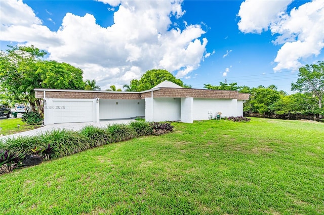view of front of property featuring a front yard, an attached garage, and concrete driveway