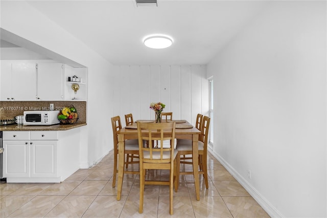 dining room with light tile patterned floors, visible vents, and baseboards