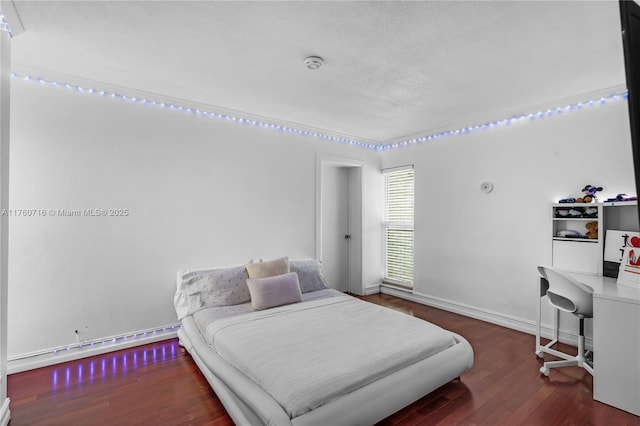 bedroom featuring a baseboard radiator, baseboards, and wood finished floors