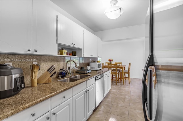 kitchen with backsplash, a sink, refrigerator, stainless steel dishwasher, and white microwave