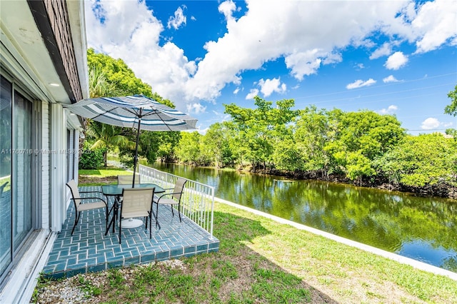 view of yard with a patio, a water view, and outdoor dining area