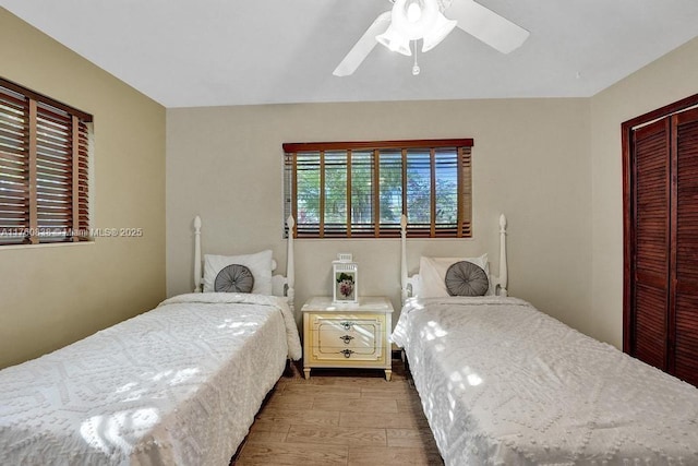 bedroom with a closet, wood finished floors, and a ceiling fan