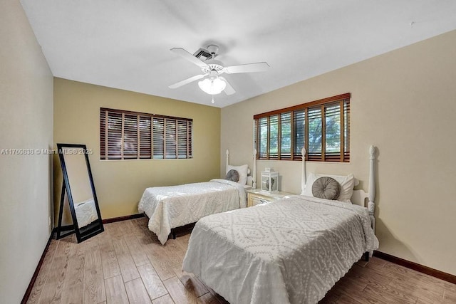 bedroom with baseboards, light wood-style floors, and a ceiling fan