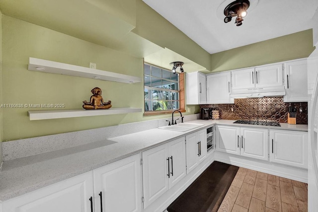 kitchen with open shelves, a sink, under cabinet range hood, white cabinetry, and black electric stovetop