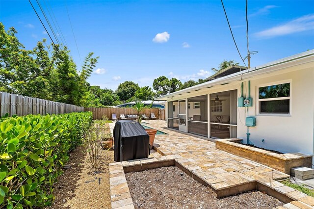 367 W Riverside Dr, Tequesta, FL 33469 - fenced backyard with a sunroom and a patio