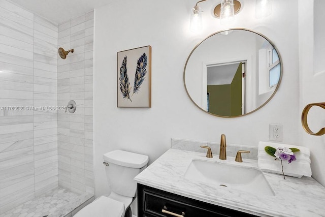 full bath with tiled shower, toilet, and vanity