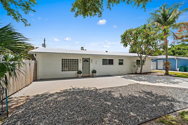 367 W Riverside Dr, Tequesta, FL 33469 - rear view of house with stucco siding, a metal roof, and a patio