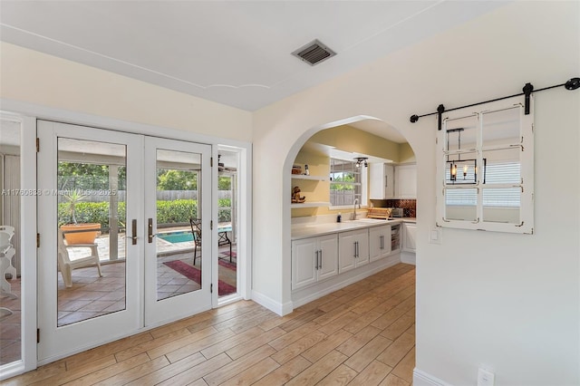 367 W Riverside Dr, Tequesta, FL 33469 - entryway featuring french doors, light wood-style floors, and arched walkways
