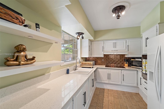 367 W Riverside Dr, Tequesta, FL 33469 - kitchen featuring white refrigerator with ice dispenser, under cabinet range hood, white cabinets, and stainless steel microwave