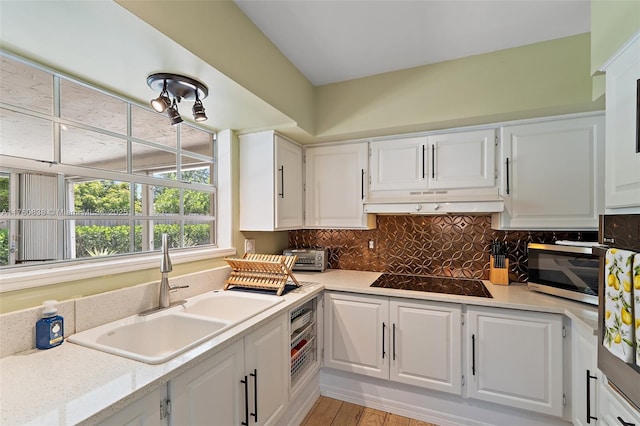 367 W Riverside Dr, Tequesta, FL 33469 - kitchen featuring black electric cooktop, stainless steel microwave, and white cabinetry