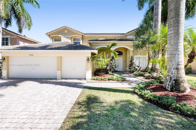 view of front of house featuring a garage, decorative driveway, stucco siding, and a tile roof