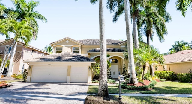 view of front of house with a garage, a tile roof, driveway, and stucco siding