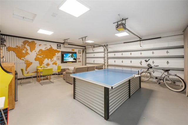 recreation room with finished concrete floors and a garage