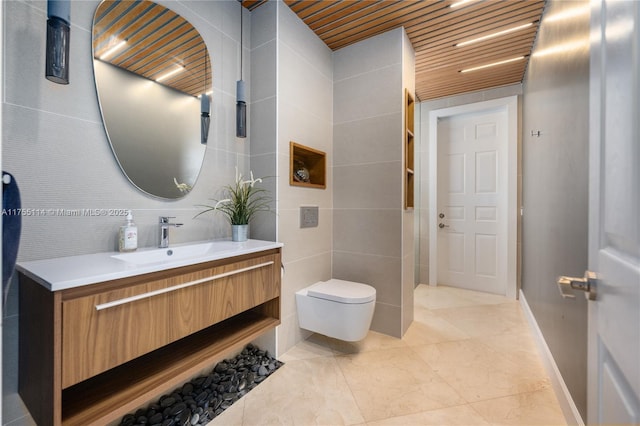 bathroom with wood ceiling, toilet, tile walls, and vanity