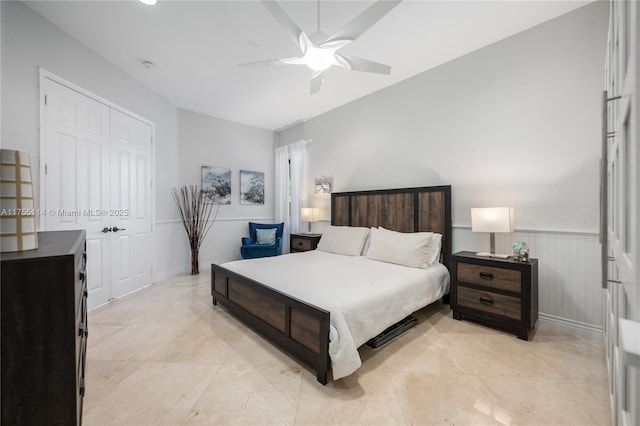 bedroom with a ceiling fan, a wainscoted wall, and a closet