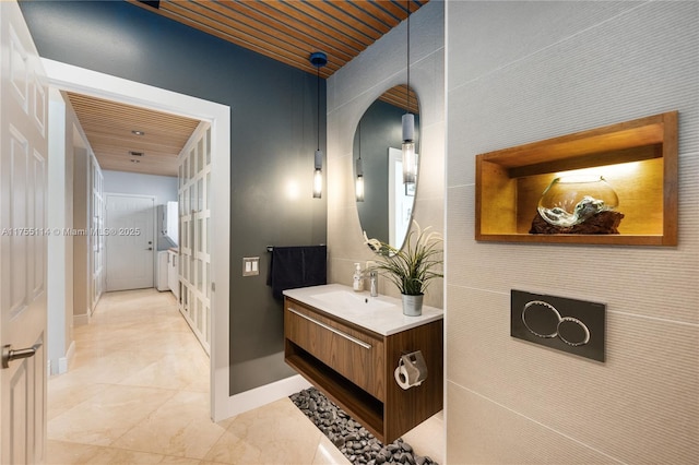 hall with wood ceiling, baseboards, and a sink