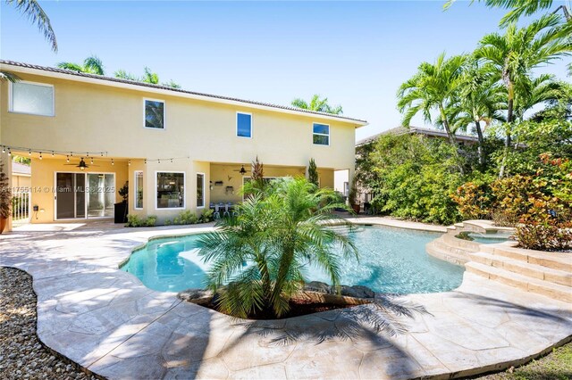 pool with a jacuzzi, a patio area, and ceiling fan