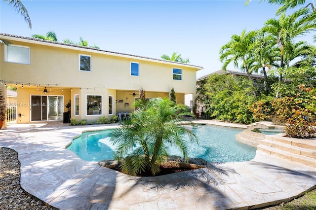 pool featuring a ceiling fan, a patio, and an in ground hot tub