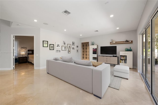 living area with recessed lighting, visible vents, and baseboards