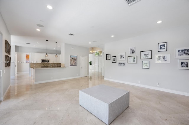 living area with recessed lighting, visible vents, and baseboards