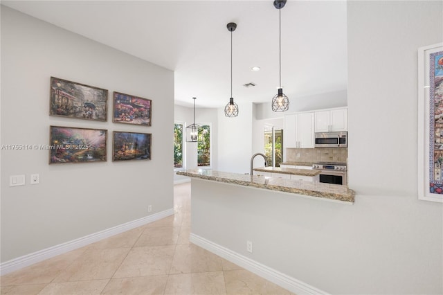 kitchen with stainless steel appliances, a peninsula, baseboards, white cabinetry, and light stone countertops