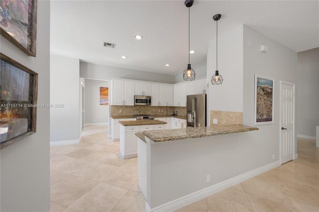 kitchen featuring light stone counters, stainless steel appliances, a peninsula, and white cabinetry