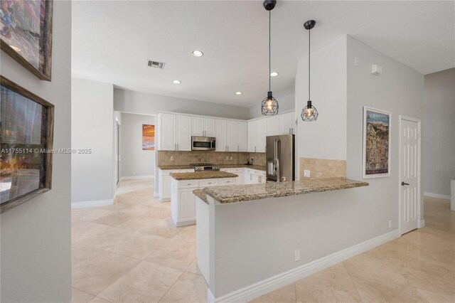 kitchen with white cabinets, light stone counters, appliances with stainless steel finishes, and tasteful backsplash