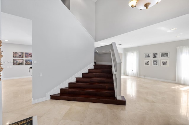 stairway featuring baseboards, tile patterned flooring, recessed lighting, and a healthy amount of sunlight