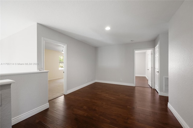 spare room featuring baseboards, visible vents, recessed lighting, and dark wood-style floors