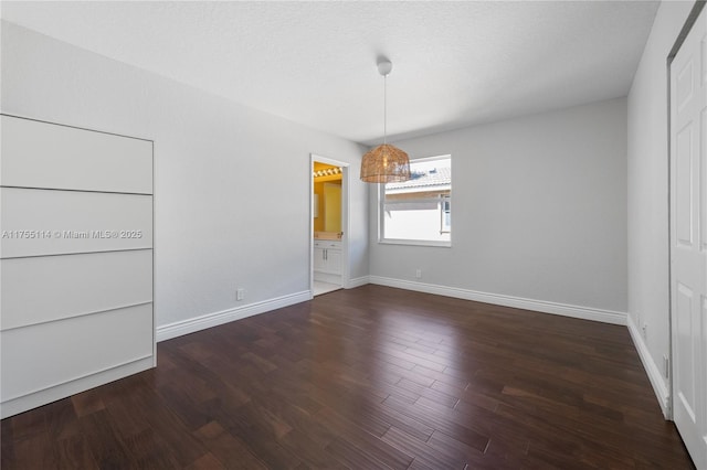 unfurnished dining area with baseboards and wood finished floors
