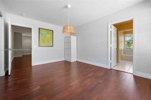 empty room with baseboards and wood finished floors