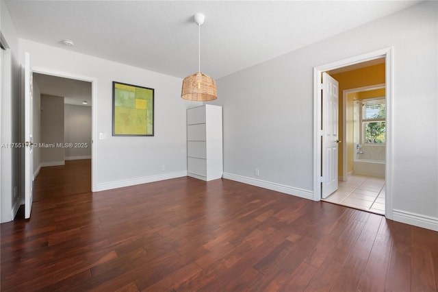 unfurnished dining area with baseboards and wood finished floors